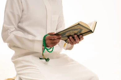 Saudi Man Reading Holy Quran with Prayer Beads