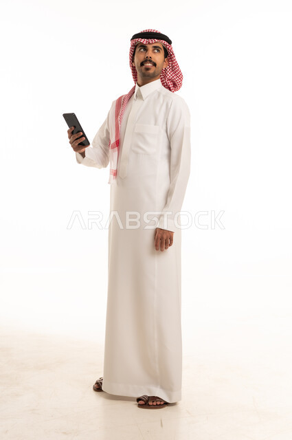 رجل سعودي يحمل هاتف ذكي بخلفية بيضاء