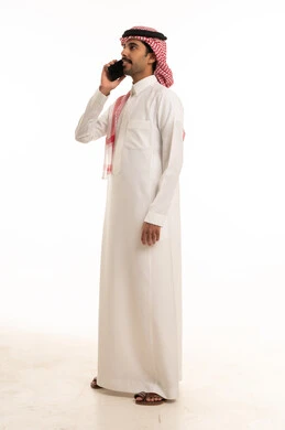 رجل سعودي يتحدث بالهاتف الذكي في استوديو أبيض