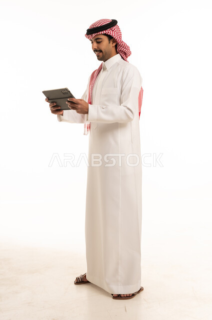 رجل سعودي يستخدم جهاز لوحي بخلفية بيضاء