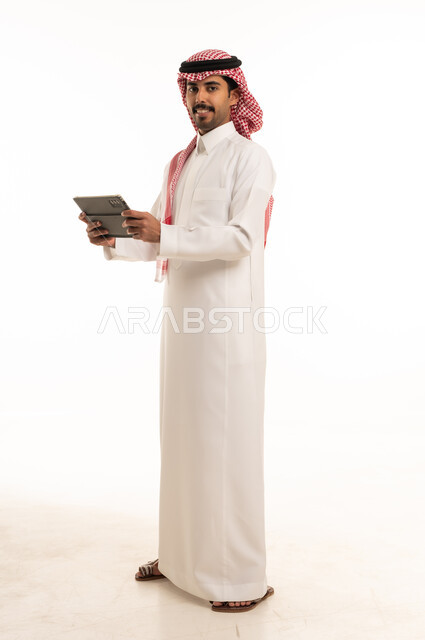 رجل سعودي مع جهاز لوحي بخلفية بيضاء