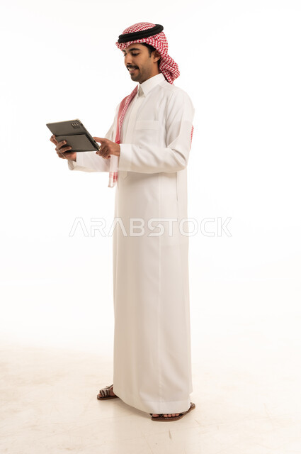 Saudi Man in Traditional Thobe Using Tablet Studio