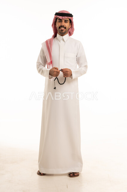 Saudi Man in Traditional Thobe Holding Prayer Beads