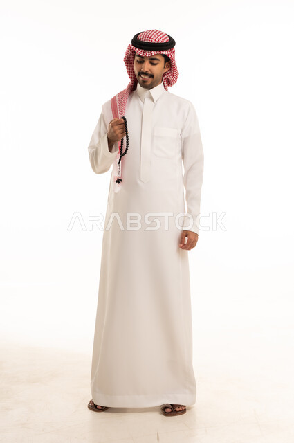 Saudi Man in Traditional Thobe Holding Prayer Beads