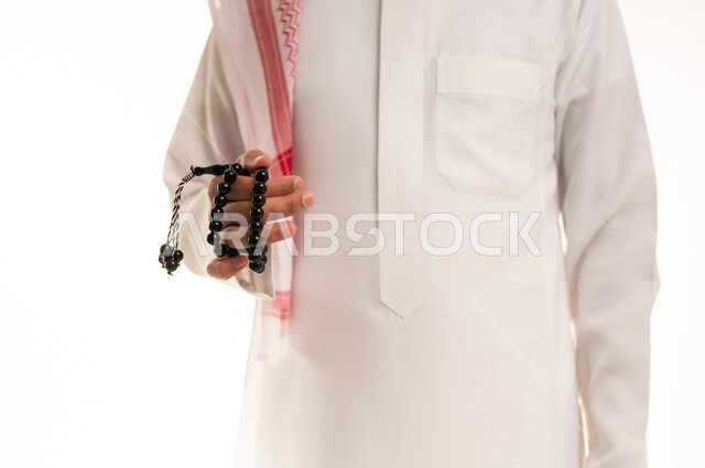 رجل سعودي بالثوب يمسك مسبحة سوداء