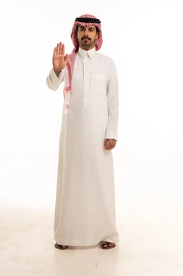 رجل سعودي بالثوب التقليدي يشير بعلامة التوقف