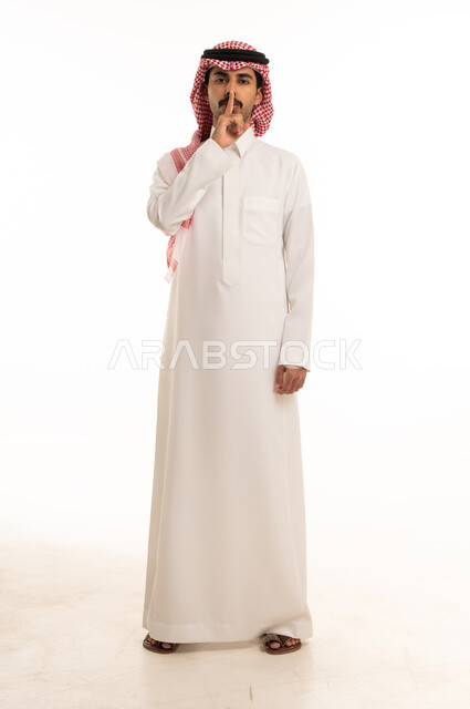 Saudi Man in Traditional Thobe Making Silence Gesture