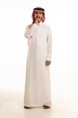 Saudi Man in Traditional Thobe Making Silence Gesture