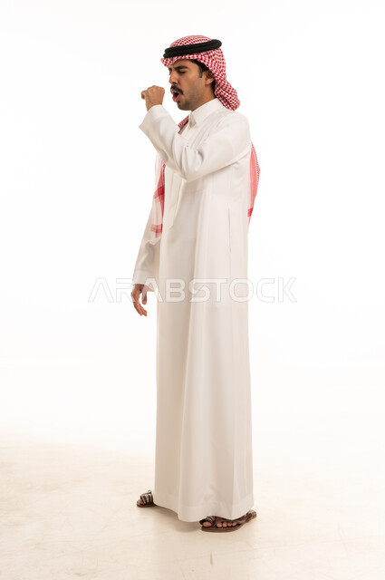 رجل سعودي بالزي التقليدي يسعل في الاستوديو