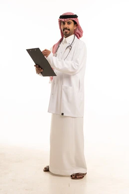 طبيب سعودي يحمل لوحة ملاحظات بالزي الطبي الرسمي