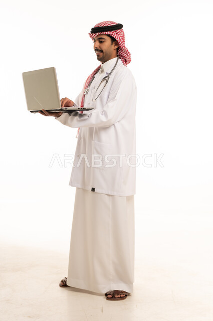 طبيب سعودي يستخدم جهاز كمبيوتر محمول بخلفية بيضاء