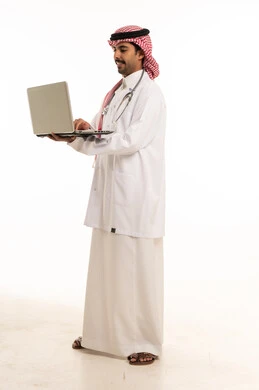 طبيب سعودي يستخدم جهاز كمبيوتر محمول بخلفية بيضاء