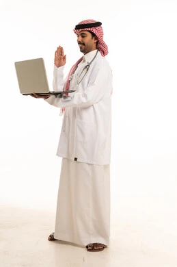 طبيب سعودي يحمل كمبيوتر محمول للاستشارة الطبية عبر الإنترنت