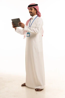 رجل أعمال سعودي يحمل جهاز لوحي بخلفية بيضاء