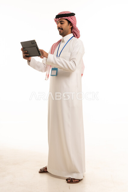 رجل سعودي يستخدم تابلت على خلفية بيضاء