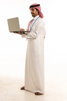 رجل أعمال سعودي يستخدم الحاسوب المحمول بخلفية بيضاء