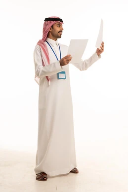 رجل سعودي يحمل أوراق عمل على خلفية بيضاء