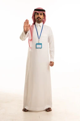 رجل سعودي بالزي التقليدي يقوم بإشارة التوقف