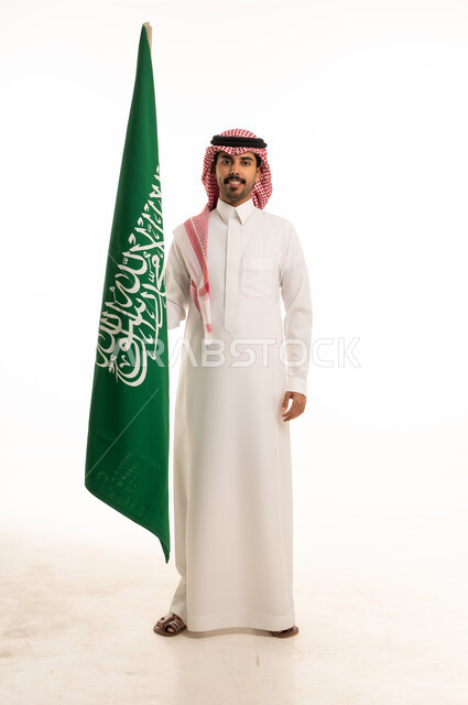 رجل سعودي يمسك العلم الوطني السعودي بخلفية بيضاء