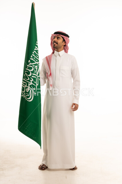 رجل سعودي يحمل علم المملكة العربية السعودية