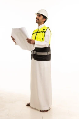 مهندس سعودي يحمل مخططات هندسية بملابس السلامة