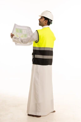 مهندس سعودي بمعدات السلامة يحمل مخطط معماري