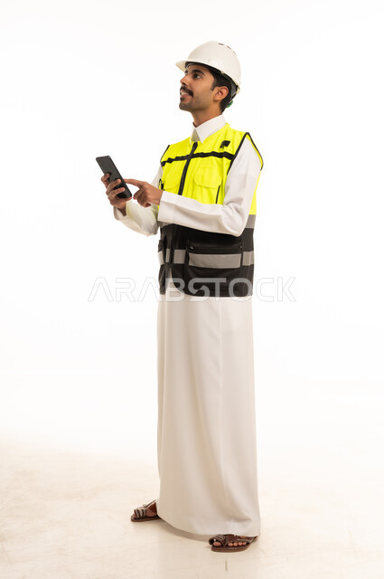 مهندس سعودي بسترة السلامة يستخدم الهاتف الذكي