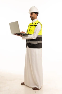 مهندس سعودي مع حاسوب محمول وسترة سلامة