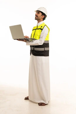 مهندس سعودي بمعدات السلامة يحمل جهاز محمول