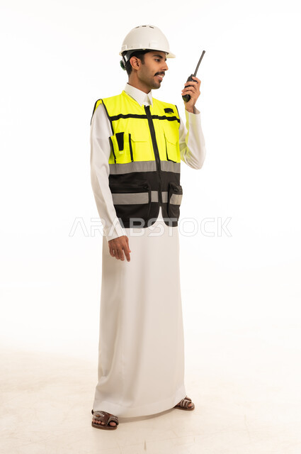 مهندس سعودي يرتدي سترة السلامة مع جهاز لاسلكي