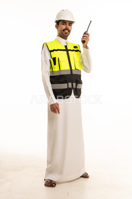 مهندس سعودي بسترة سلامة وجهاز لاسلكي