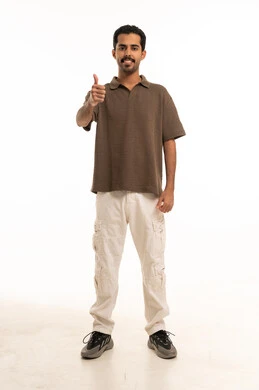 شاب سعودي يقوم بإيماءة الإبهام على خلفية بيضاء