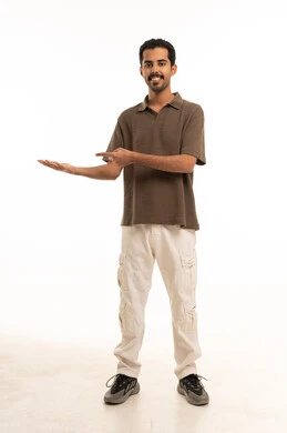 رجل سعودي مبتسم يشير بيده على خلفية بيضاء