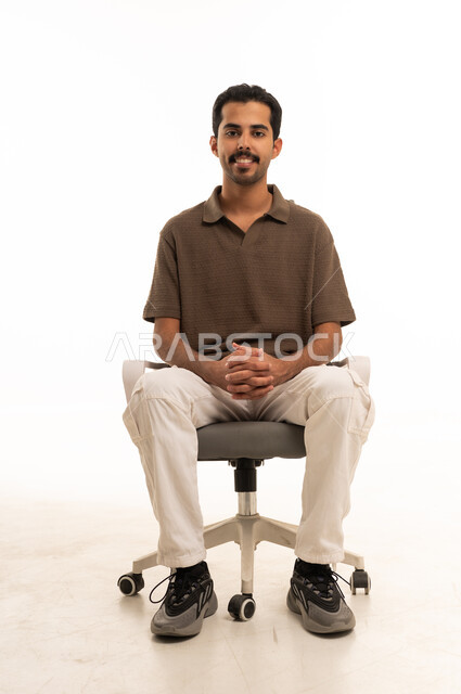 رجل سعودي يجلس على كرسي مكتب خلفية بيضاء