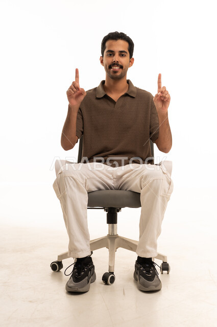 شاب عربي يشير للأعلى جالس على كرسي مكتب خلفية بيضاء