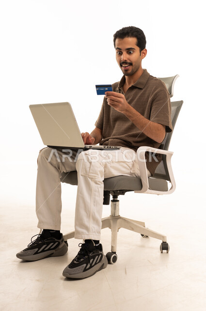 Saudi Man Using Laptop and Credit Card with Surprise