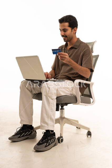 Arab Man Using Laptop and Credit Card for Online Shopping