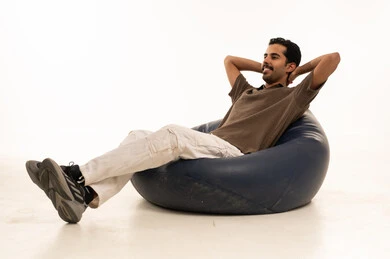 رجل سعودي يسترخي على كرسي بين باج خلفية بيضاء