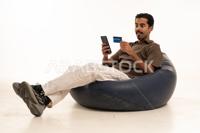 Saudi Man Online Shopping with Credit Card on Beanbag