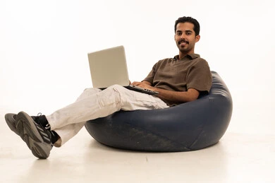 رجل عربي مع لابتوب على مقعد استرخاء