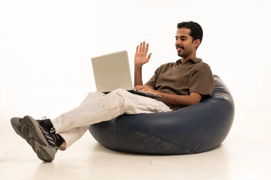 Saudi Man on Laptop Video Call in Bean Bag