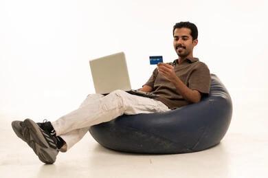 رجل سعودي يستخدم اللابتوب والبطاقة البنكية