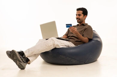 رجل عربي يستخدم بطاقة ائتمان ولاب توب