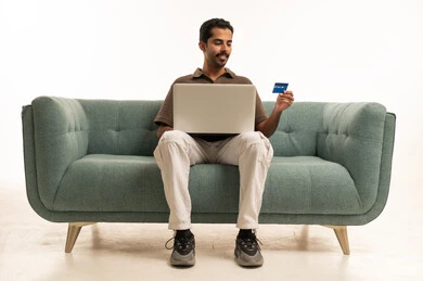 Saudi Man Shopping Online with Laptop on Sofa