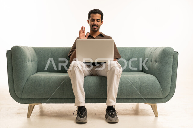 رجل سعودي يلوح أثناء مكالمة فيديو على اللابتوب