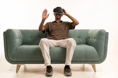 Saudi Man Using VR Headset on Sofa in Studio