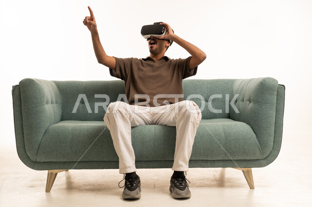 Saudi Man Using VR Headset on Sofa in Studio