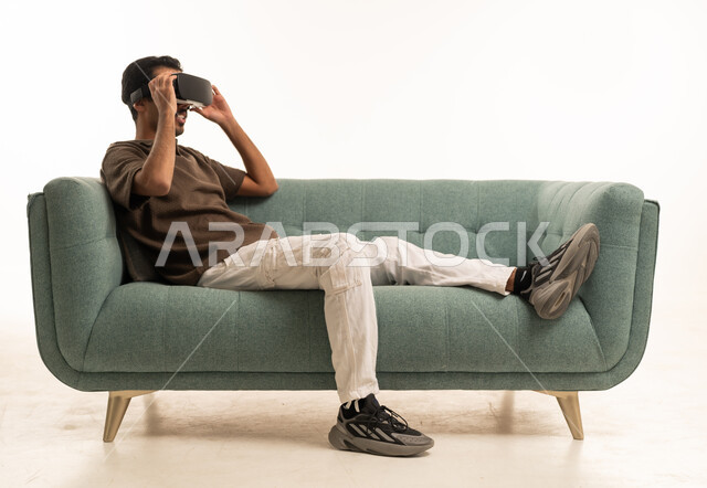 Arab Man Using VR Goggles on Sofa Studio Shot