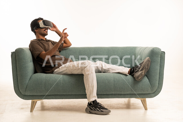 Arab Man Using VR Headset on Green Sofa