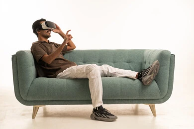رجل عربي يستخدم نظارة الواقع الافتراضي على الأريكة
